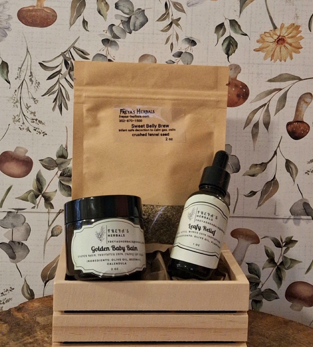 The Hush Little Baby Collection: Golden Baby Balm, Sweet Belly Brew, and Leafy Relief in a wooden crate